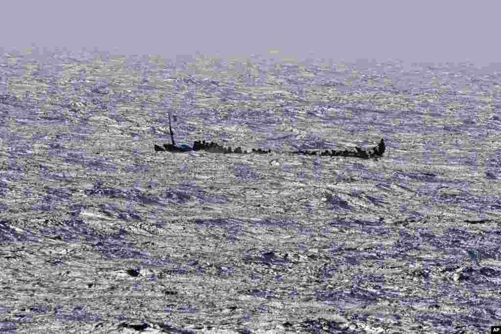 Migrants crowd a wooden boat as they sail to the port in La Restinga on the Canary island of El Hierro, Spain, Aug. 18, 2024. Emergency services on Spain's Canary Islands say 175 migrants have arrived in a boat on the Canary Island of El Hierro, after a seven-day sailing from the coast of Senegal. 