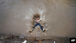 A boy jumps into a canal on a hot day in Jammu, India, June 20, 2023. Many parts of India are experiencing scorching heat this summer. 