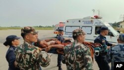尼泊爾西部11月4日發生強烈地震。 救援的軍人抬著受傷者離開山村。