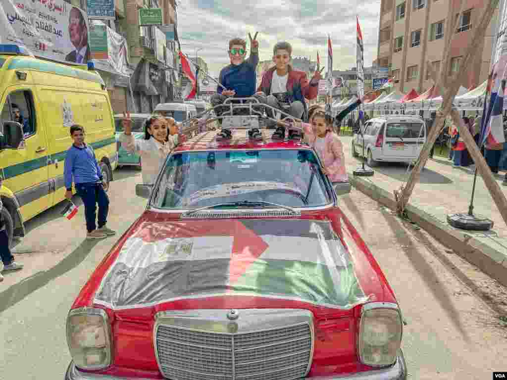 A family shows solidarity with Sissi and Palestinians near a polling station, just 30 miles from Egypt’s border with war-torn Gaza, where aid agencies say the humanitarian crisis is among the worst they have witnessed. Arish, Egypt, Dec. 10, 2023. (Hamada Elrasam/VOA)
