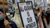 Seorang perempuan memegang poster bertuliskan, "Al-Qur'an adalah kehormatan kami" dalam aksi protes di depan kedutaan besar Swedia di Kuala Lumpur, Malaysia, pada 27 Januari 2023. (Foto: Reuters/Hasnoor Hussain)