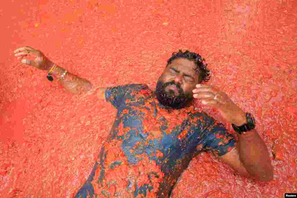 Participante deitado em polpa de tomate no festival anual de luta de comida “La Tomatina” em Bunol, perto de Valência, Espanha, 28 de agosto de 2024. 