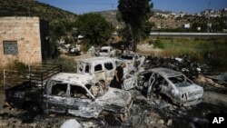 Seorang pria Palestina memeriksa mobil-mobil yang hangus dibakar pasca serangan oleh pemukim Yahudi terhadap desa A Laban al-Sharkiyeh di Tepi Barat, Rabu 21 Juni 2023.