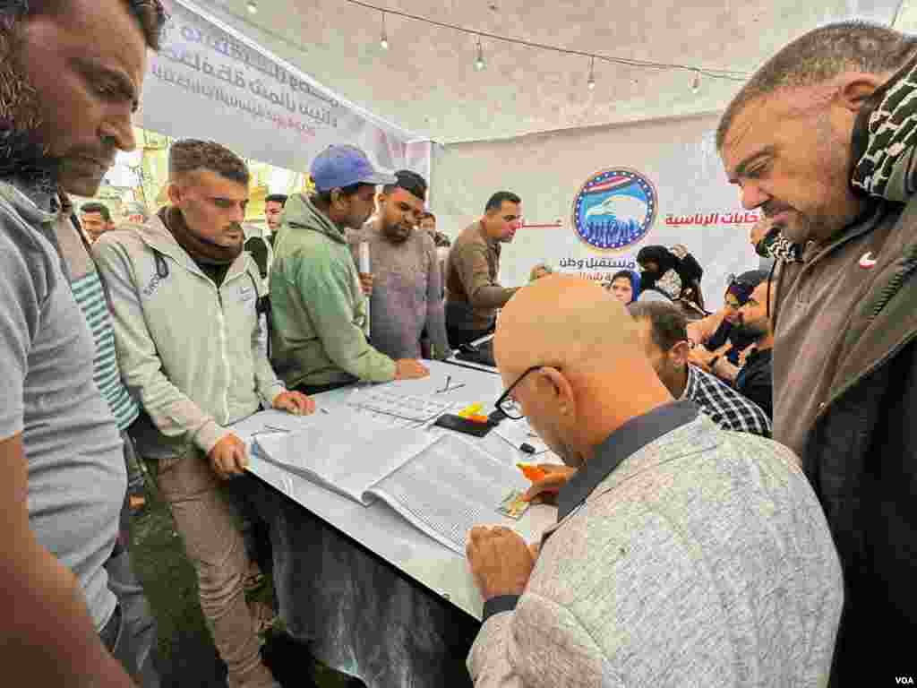 Volunteers from the Sissi-aligned party of Mostakbal Watan (Nation's Future Party) assist voters in Arish, especially those who are illiterate in a region plagued by poverty and instability. In Arish, Egypt, Dec. 10, 2023. (Hamada Elrasam/VOA)