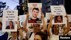 Para pengunjuk rasa memegang poster menuntut pembebasan sandera yang ditahan Hamas pada 7 Oktober, di Tel Aviv, Israel 21 November 2023. (Foto: REUTERS/Amir Cohen)