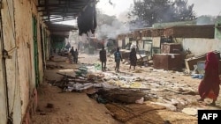 Sejumlah warga tampak berjalan di sebuah pasar yang porak poranda di El Geneina, Darfur barat, pada 29 April 2023, di tengah perang Sudan yang terus bergejolak. (Foto: AFP)