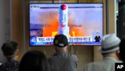 지난 5월 한국 서울역 이용객들이 북한 정찰위성 발사 관련 TV뉴스를 시청하고 있다. (자료사진)
