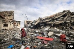 Warga Palestina memeriksa kehancuran akibat serangan Israel di Wadi Gaza, di Jalur Gaza tengah pada 28 November 2023, di tengah gencatan senjata antara Israel dan Hamas. (Foto: AFP)