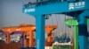 Sebuah derek mengangkat kontainer pengiriman di pelabuhan kontainer otomatis di Tianjin, China, 16 Januari 2023. (Foto: AP)