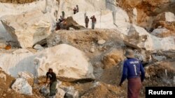 FILE - Workers move pieces of extracted marble from a marble mine in Sagyin, Mandalay, Myanmar, Feb. 15, 2019.