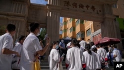 圖為2023年6月7日，中國的應屆高中畢業生們在一個中學外排長隊參加每年一次的“全國高校統一考試”，俗稱“高考”，一名警察站在一旁注視著排隊的學生。今年全中國有超過120萬的高中畢業生參加高考。