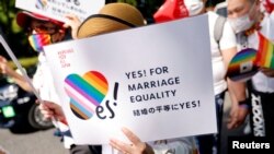FILE— A participant holds a sign as they march during the Tokyo Rainbow Pride parade, celebrating advances in LGBTQ rights and calling for marriage equality, in Tokyo, Japan April 23, 2023. 