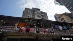 People look out from a common balcony of a Chawl, home to hundreds of families, during a 21-day nationwide lockdown to slow the spreading of coronavirus disease (COVID-19), in Mumbai, India, March 31, 2020.