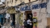FILE - People stand near a building destroyed after a deadly siege by al-Shabab militants in Mogadishu, Somalia, Aug. 21, 2022. The Somali government said on Sunday that its elite soldiers have kllled 21 al-Shabab militants and wounded 10 others.