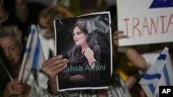 Aksi protes atas kematian Mahsa Amini, seorang wanita yang meninggal saat dalam tahanan polisi di Iran, saat demonstrasi di Tel Aviv, Sabtu, 29 Oktober 2022. (AP Photo/Ariel Schalit)