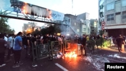 Demonstrators light a fire during a protest over the death of Mahsa Amini while in custody of Iran's morality police, in Tehran, Sept. 21, 2022. (West Asia News Agency via Reuters)