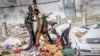 Rescuers and security forces stand by a dead body at the scene of a double car-bomb attack in Mogadishu, Somalia, Oct. 29, 2022. 