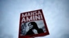 FILE - A woman holds a placard with a picture of Iranian Mahsa Amini during a protest against her death, in Berlin, Germany, Sept. 28, 2022. 