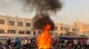 A picture obtained by AFP outside Iran, shows people gathering next to a burning motorcycle in the capital Tehran on October 8, 2022.