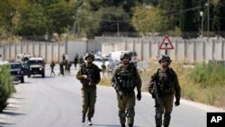 Israeli military forces work near the site where a soldier was killed by gunfire near the West Bank Jewish settlement of Shavei Shomron, Oct. 11, 2022. 