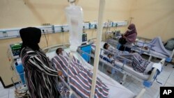 Relatives stand nearby as survivors of Saturday's soccer riots are treated at a hospital in Malang, East Java, Indonesia, Oct. 3, 2022.