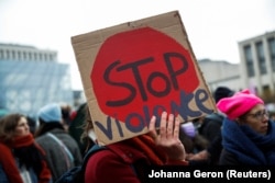 Seorang demonstran memegang plakat selama protes nasional terhadap ketidaksetaraan, kekerasan, KDRT dan pelecehan seksual terhadap perempuan di Brussels, Belgia, 28 November 2021. (Foto: REUTERS/Johanna Geron)