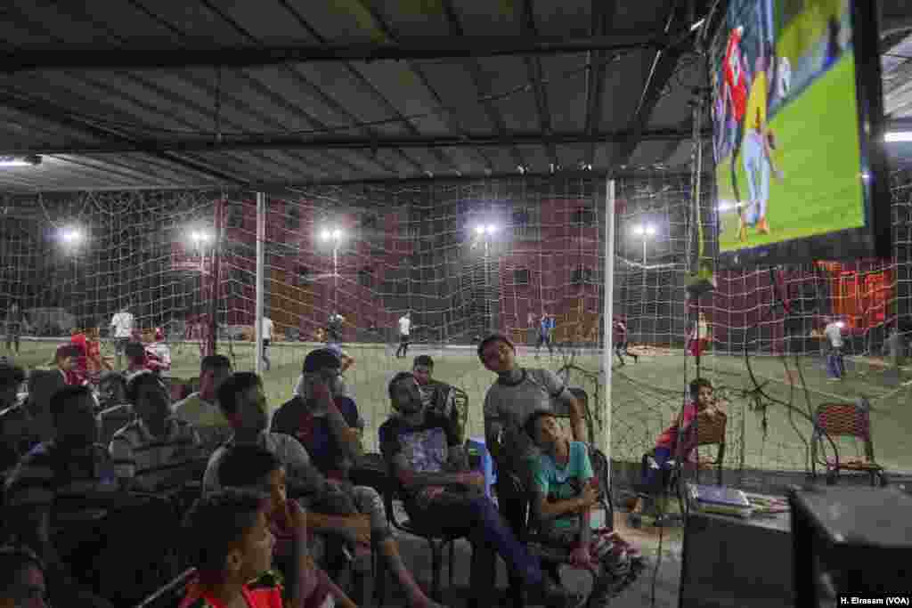 Residents of Mohamed Salah’s hometown, Nagrig, gather at a cafe to watch a football match while local football league play in a soccer playground that is part of the cafe.
