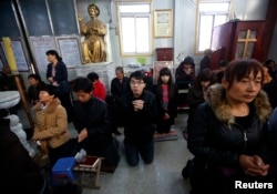 FILE - Believers take part in a weekend mass at an underground Catholic church in Tianjin .