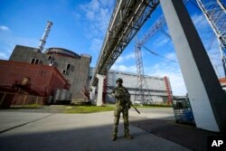 Seorang prajurit Rusia menjaga area Pembangkit Listrik Tenaga Nuklir Zaporizhzhia di wilayah yang dikenadlikan militer Rusia, Ukraina tenggara, pada 1 Mei 2022. (Foto: AP)