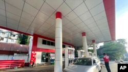FILE - An attendant pumps fuel into a taxi at a gas station in Botahtaung township in Yangon, Myanmar, on Nov. 12, 2021. 