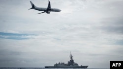 FILE - A Royal Australian Air Force P-8A Poseidon aircraft making a low pass over Royal Australian Navy destroyer HMAS Hobart during Fleet Certification Period, Feb. 24, 2022