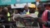 Motorcycle riders read The Standard, a local daily newspaper, with a headline reporting the election of Kenya's 5th President elect William Ruto, in Eldoret, Aug. 16, 2022. 