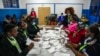 FILE - Election officials count votes at a polling station in Kilimera Primary School in Nairobi, Kenya, Aug. 9, 2022.