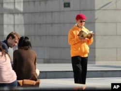 Dalam foto Desember 2013 ini, Xiao Jianhua, miliarder Kanada kelahiran China, membaca buku di luar International Finance Center di Hong Kong. (Next Magazine via AP)