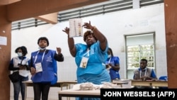Trabalhador eleitoral exibe boletim de voto durante contagem em precinto em Luanda (24 Agosto 2022)