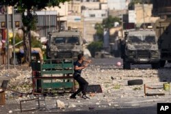 Demonstran Palestina bentrok dengan tentara Israel saat pasukan melakukan operasi penggerebekan di kota Nablus, Tepi Barat, Selasa, 9 Agustus 2022. (AP/Majdi Mohammed)