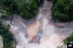 In this aerial photo, a community reservoir that ran nearly empty after its retaining wall started to leak and hot weather and drought conditions accelerated the loss of water is seen in Longquan village in southwestern China's Chongqing Municipality, Aug. 20, 2022.