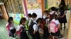 Students wearing face masks form a line as they enter their classroom during the opening of classes at a school in Quezon City, suburban Manila on Aug. 22, 2022 as millions of children in the Philippines returned to school as the academic year started.