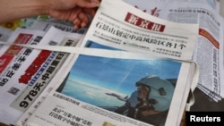 北京街头报摊上的报纸头版展示中国空军参加在台湾周边海空领域进行军演的照片。（2022年8月8日）（路透社）