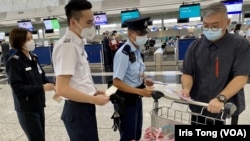香港警方联同入境处人员8月20日下午在香港国际机场，向准备前往泰国曼谷的游客派发传单，呼吁东南亚诈骗集团求职连片按騙集團求職騙案。（美国之音汤惠芸报道）