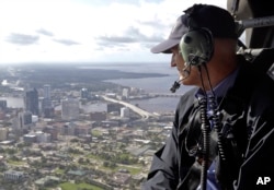 FILE - In this Sept. 12, 2017 photo, Gov. Rick Scott assesses flooding damage over Jacksonville, Florida, in the aftermath of Hurricane Irma.