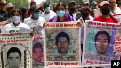 Family members and friends march seeking justice for the missing 43 Ayotzinapa students in Mexico City, Aug. 26, 2022.