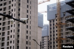 上海一處正在修建的公寓樓盤旁豎立著一個監控攝像頭。（2022年7月20日）