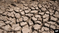 FILE - Cracked dry mud is seen in a community reservoir that ran nearly empty in southwestern China's Chongqing Municipality, Aug. 20, 2022.