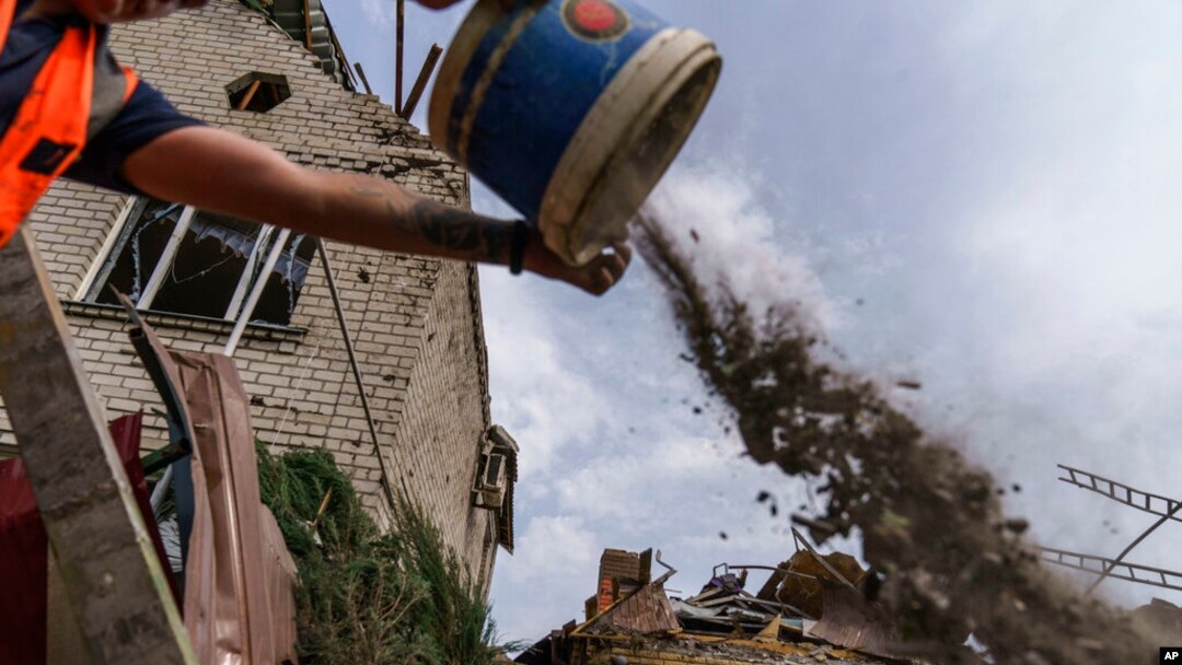 A worker cleans debris from a rocket strike on a house in Kramatorsk, Donetsk region, eastern Ukraine, Aug. 12, 2022.