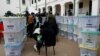 Police officers and polling staff sort sealed ballot boxes containing electoral materials at an Independent Electoral and Boundaries Commission (IEBC) tallying centre after the general election at the Jamuhuri High School in Nairobi, Aug. 10, 2022. 