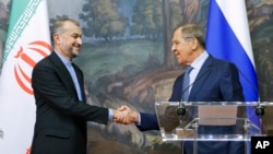 Russian Foreign Minister Sergey Lavrov, right, and Iranian Foreign Minister Hossein Amir-Abdollahian shake hands after a joint news conference following their talks in Moscow, Russia, Aug. 31, 2022.