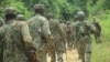 FILE - Ugandan troops are seen on a road in the Beni district of the Democratic Republic of Congo, Dec. 8, 2021. This week, a contingent from Burundi arrived in the DRC as part of an East African regional force deployment to counter violence by rebel groups.
