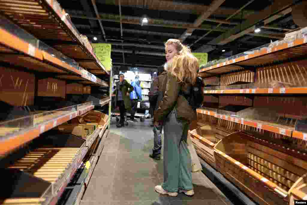 A woman looks at empty shelves of bread after the curfew was lifted as Russia's invasion of Ukraine continues, in Kyiv, Ukraine, Feb. 28, 2022.