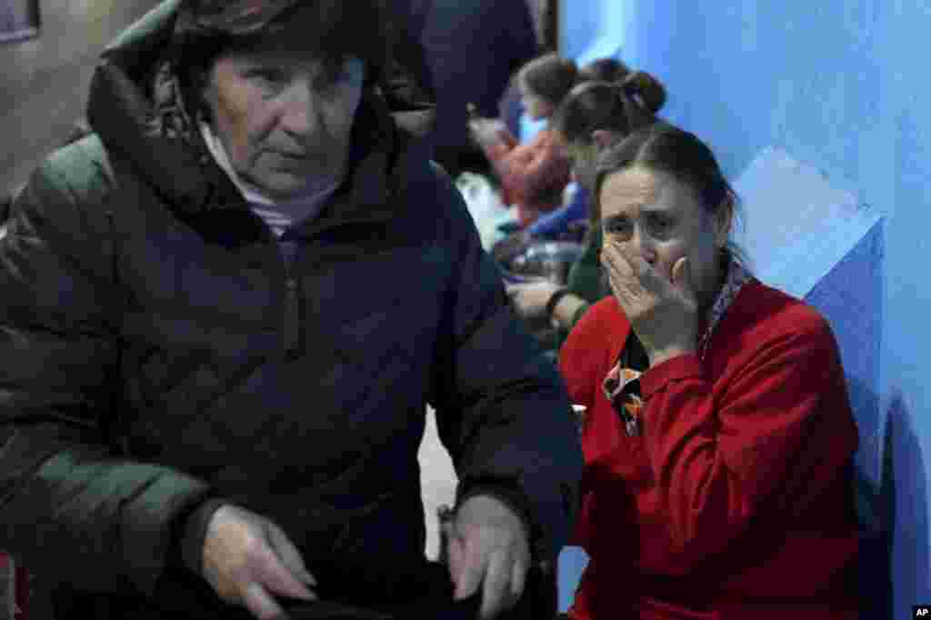 People take shelter inside a building in Mariupol, Ukraine, Feb. 27, 2022. Street fighting broke out in Ukraine's second-largest city and Russian troops squeezed strategic ports in the country's south as the prospect of peace talks remains uncertain.